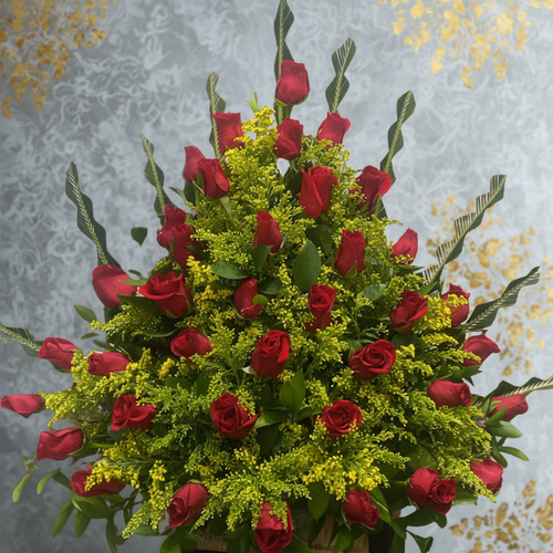 Arreglo floral en forma de abanico con rosas rojas y flores amarillas sobre fondo gris decorado con detalles dorados